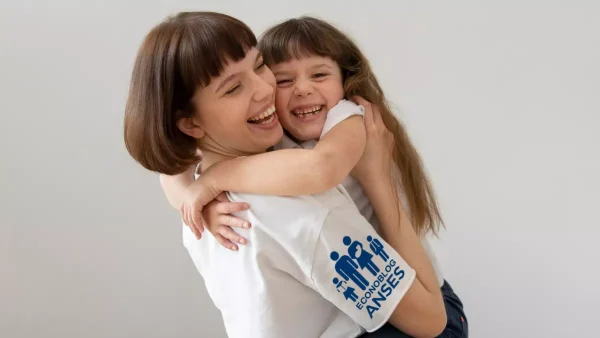 Madre con su hija con remera de Anses y AUH