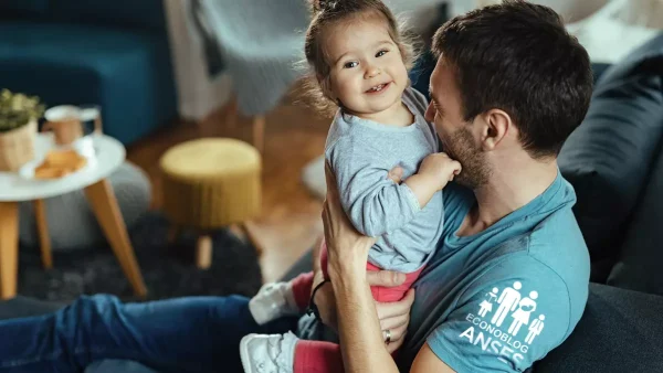 Padre de la AUH con su hija y remera de Anses