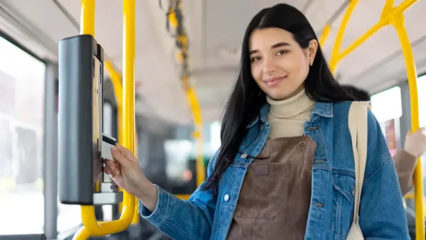 Joven sacando un boleto en el colectivo con su Tarjeta SUBE