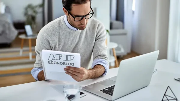 Trabajador con un cuaderno de AFIP y una computadora