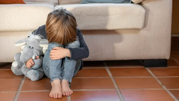 Niño triste con su peluche