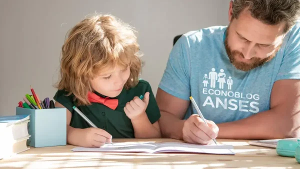 Padre de la AUH con remera de Anses haciendo la tarea