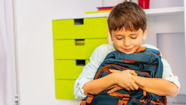 Estudiante abrazado a su mochila