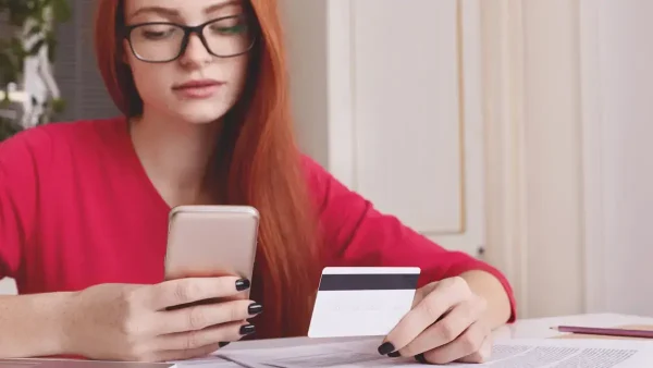 Mujer con su tarjeta de crédito y teléfono celular