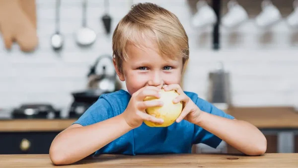 Chico comiendo una manzana