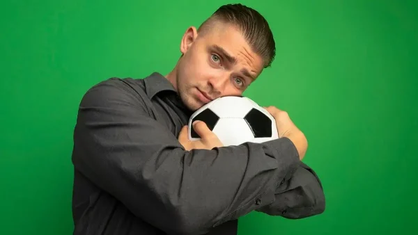 Hombre abrazado a la pelota de fútbol
