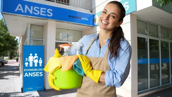 Empleada del servicio doméstico en Anses con cartel de AUH