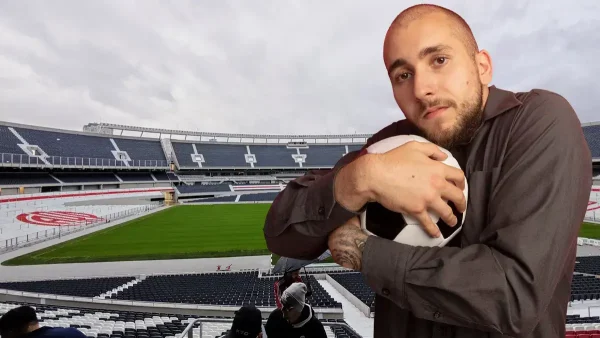 Hombre abrazado a una pelota de fútbol