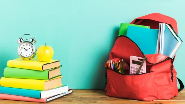 Mochila junto a libros y a un reloj