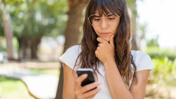 Mujer pensando con su celular
