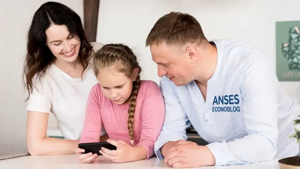 Familia con camisa de Anses mirando el celular