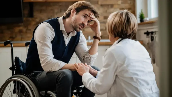 Doctora atendiendo a persona con discapacidad