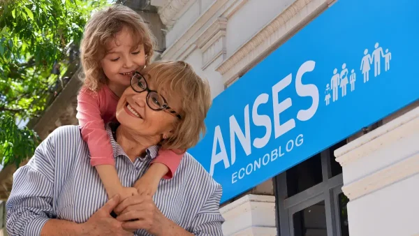 Abuela con nieta en Anses con cartel de AUH y SUAF