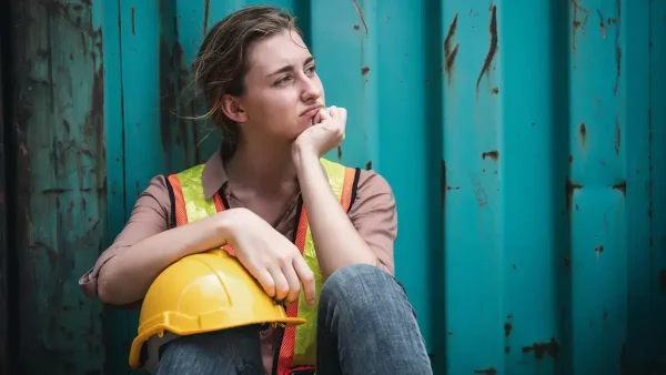 Trabajadora con casco pensando