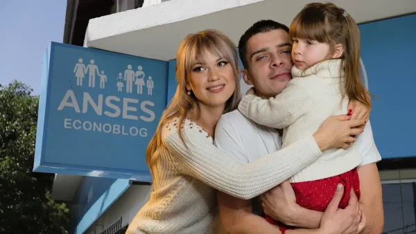 Familia en Anses con cartel de SUAF y AUH