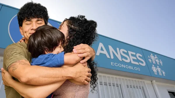 Familia abrazada en Anses junto a cartel del SUAF y AUH