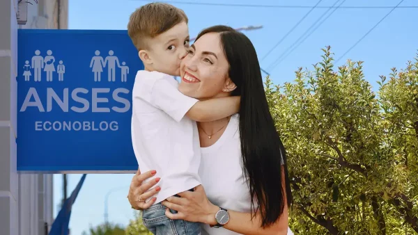 Madre en Anses junto a cartel de AUH y SUAF