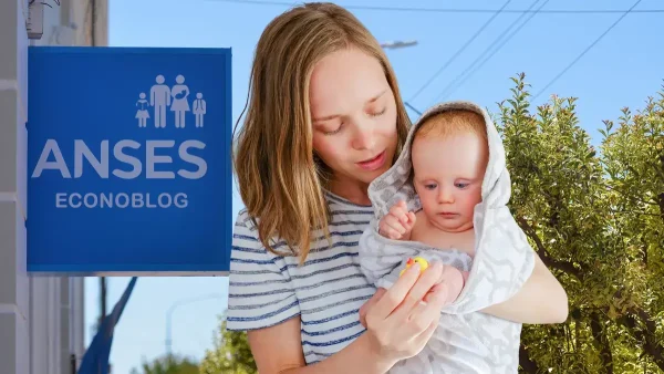 Bebé de la AUH frente a cartel de Anses