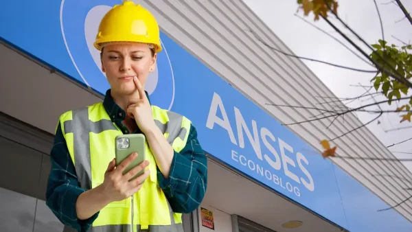 Trabajadora pensando con su celular en Anses
