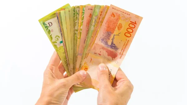 Manos con billetes de pesos