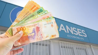 Mano con billetes de pesos en Anses