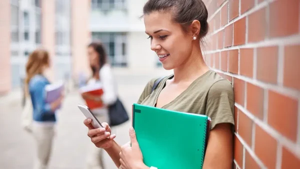 Estudiante con libros y su celular