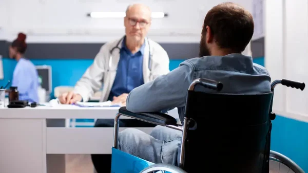Médico atendiendo a persona con discapacidad