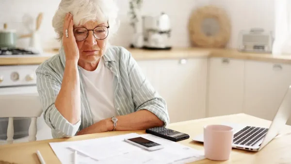 Jubilada preocupada con una calculadora