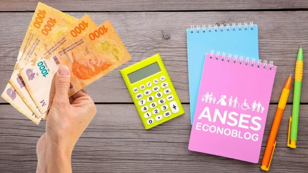 Cuaderno de Anses junto a calculadora y pesos