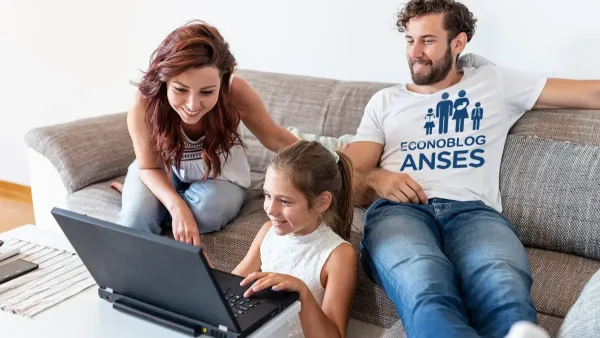 Familia de la AUH con remera de Anses y computadora