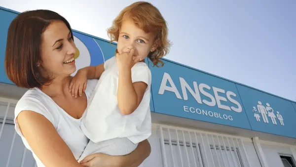 Madre frente a cartel de Anses y AUH