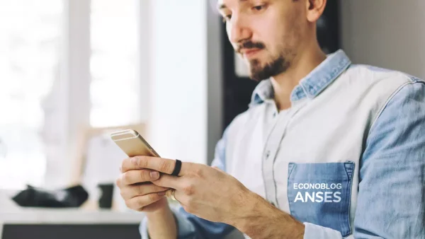 Persona con celular y camisa de Anses