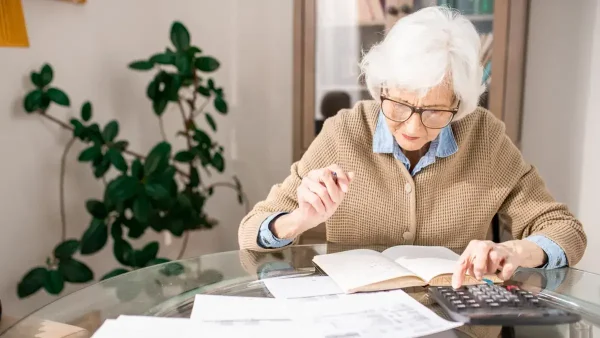 Jubilada haciendo cuentas con una calculadora