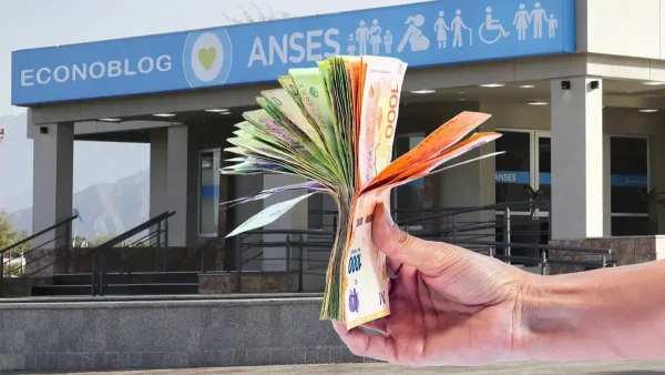 Mano con billetes de pesos en Anses