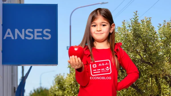 Titular de la Tarjeta Alimentar junto a cartel de Anses
