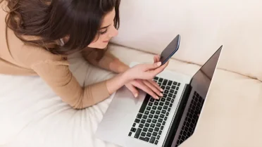 Mujer con su computadora y celular