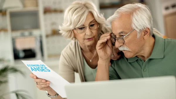 Jubilados leyendo un papel de Anses