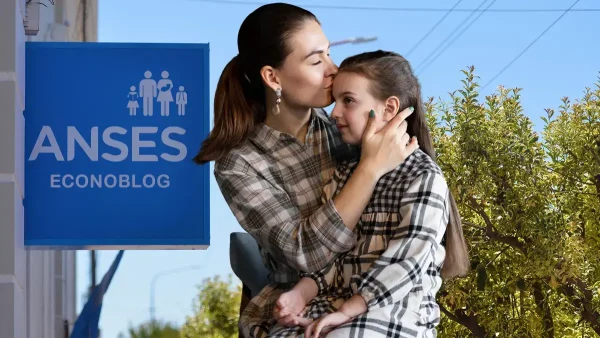 Madre de la AUH frente a cartel de Anses